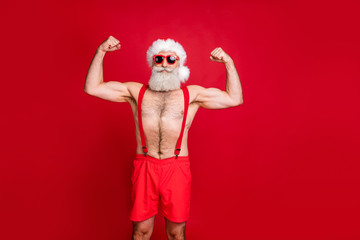 Portrait of his he nice attractive content serious strong powerful cool gray-haired man St Saint Nicholas bodybuilder showing muscles isolated over bright vivid shine red background