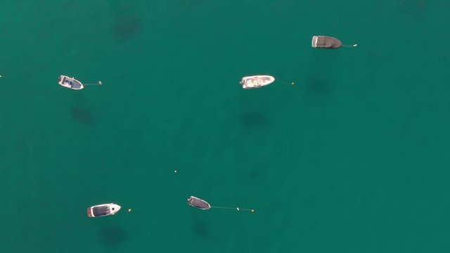 a professional looking aerial of the crystal clear adriatic sea in the mediterranean, rising over some boats with islands in sight