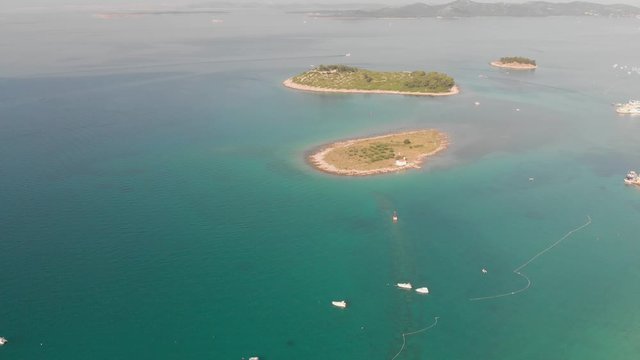 a professional looking aerial of the crystal clear adriatic sea in croatia, flying towards the small islands in front of pakostane
