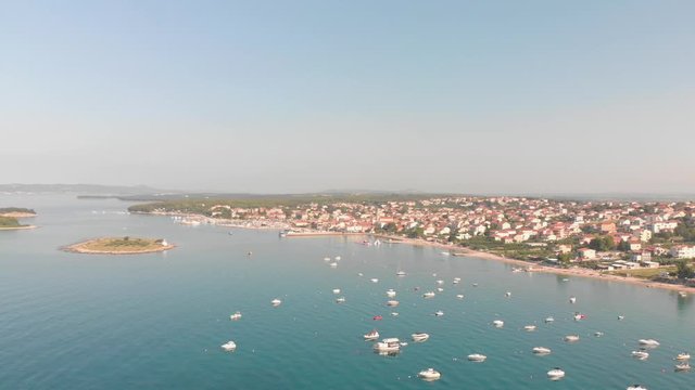 a professional looking aerial of the crystal clear adriatic sea in south croatia, flying towards a small town called pakostane