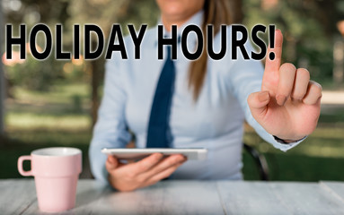 Conceptual hand writing showing Holiday Hours. Concept meaning Overtime work on for employees under flexible work schedules Female business person sitting by table and holding mobile phone