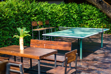 Outdoor adapted Table tennis in the recreation and relax zone on wood stage in garden area.