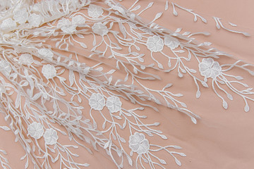 Texture lace fabric. lace on white background studio. thin fabric made of yarn or thread. a background image of ivory-colored lace cloth. White lace on beige background.