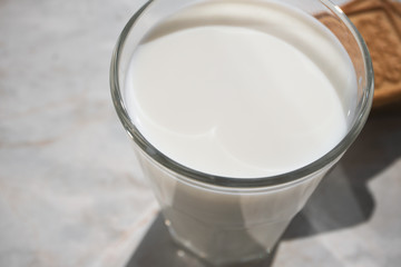 Close-up of milk surface in glass and shortbread on background