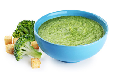 Bowl of green cream soup with pea, broccoli, spinach, kale and croutons isolated on white background.