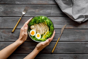 Healthy dinner in bowl on wooden background top view