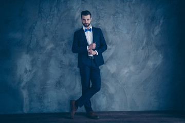 Full length photo of charming executive fixing his sleeve looking wearing blazer jacket trouser pants isolated over grey background