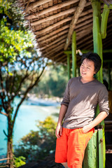Fototapeta premium Asian Thai Chinese man smile and relax in this vacation day at the weekend in nature environment in green vintage pavilion
