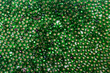 Beautiful green beads on a one-ton light background. Object group. This can be used as a background.
