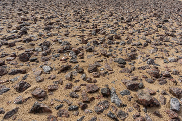 A scattering of granite rubble rammed into sand