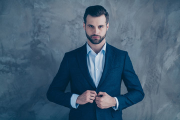 Portrait of gorgeous man looking glancing wearing suit blazer jacket isolated over grey background