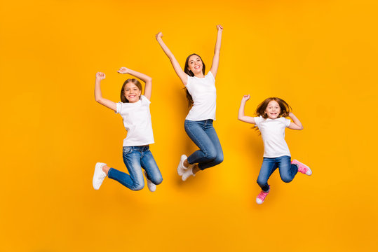 Full size photo of jumping high ladies rejoicing wear casual clothes isolated yellow background
