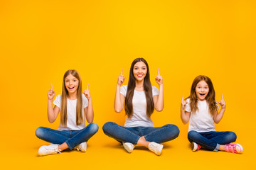 Photo of amazing ladies sitting floor with crossed legs indicating empty space wear casual clothes isolated yellow background