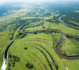 Aerial landscape of winding river in green fields