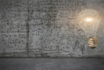 A bright light bulb against the background with maths and science sketches on a wall