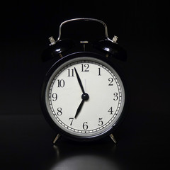 Classic mechanical alarm clock on dark background. Low key