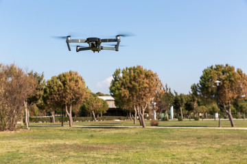 A drone with digital camera flying in the park