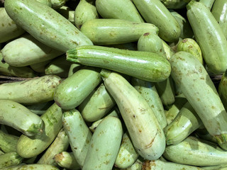 Ugly food concept. A bunch of ugly zucchini lie in the store. Background of ugly zucchini