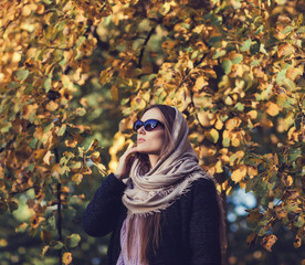 glamorous lady in autumn coat and scarf posing in the Park