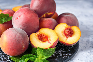 Board with tasty peaches on table