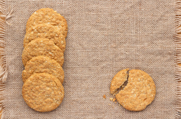 Homemade oat and wholemeal biscuits isolated on brown sackcloth background. Its are a nutrient-rich food associated with protein, fiber and no artificial flavours or colour added.