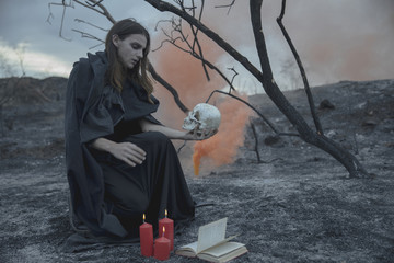 Man sitting with a skull in his hand and looking at it