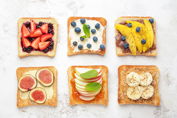 Different tasty sandwiches on light background