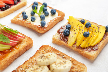 Different tasty sandwiches on light background