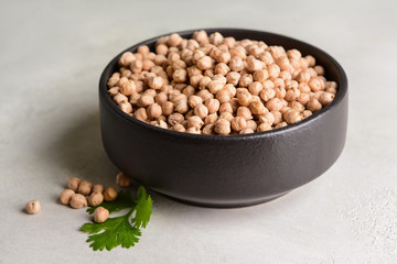 Bowl with raw chickpea on table