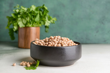 Bowl with raw chickpea on table
