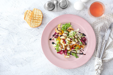 Plate with tasty salad on table