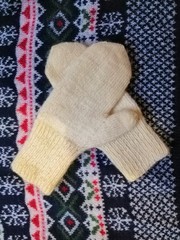 white mittens on the background of a winter sweater