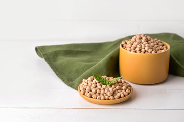 Plate and container with raw chickpea on table