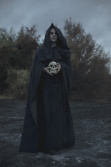 Long portrait of a man dressed as dark mage with skull