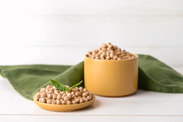 Plate and container with raw chickpea on table