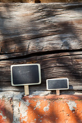 An information sign stands on a brick and wooden obsolete wall