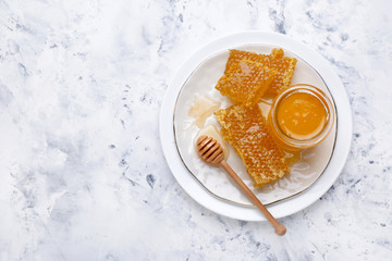 Plate with sweet honey and combs on table