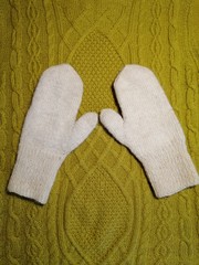 white mittens on the background of a winter sweater