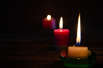 Beautiful light candles with frames on black background.
