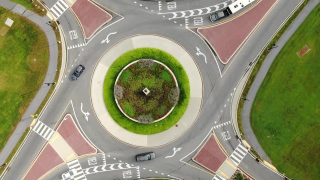 Aerial top down orbiting, rotating drone view of traffic circle roundabout
