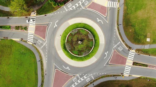 Aerial top down static drone view of traffic circle roundabout with a few cars