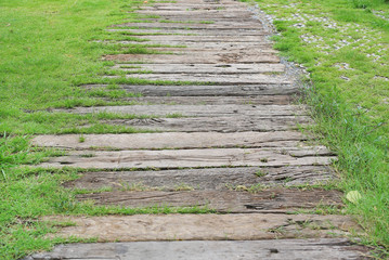 Wooden step with green grass around in garden.