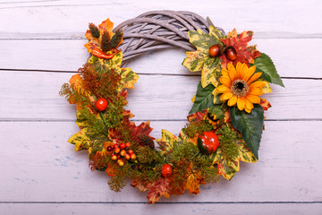 Vintage autumn wreath from leaves and flowers on shabbi wooden backgorund