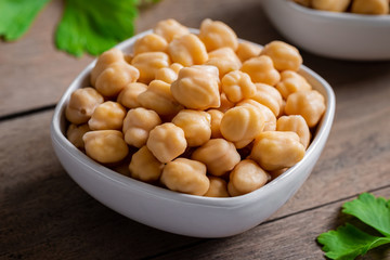 Cooked chick peas in white bowl.
