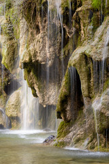 Fototapeta na wymiar Detalle de una bella cascada en el nacimiento del río Cuervo, cerca de la población de Vega del Codorno. Castilla La Mancha. España