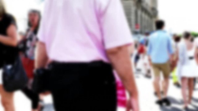 Tourists and locals walking along the pedestrian street of the old European city. 4K. Blurred view