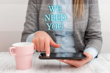 Handwriting text writing We Need You. Conceptual photo asking someone to work together for certain job or target Business woman sitting with mobile phone and cup of coffee on the table