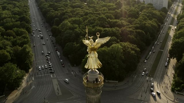 The Berlin Victory Column with the Golden Lizzy inside the Tiergarten in central berlin. The statue is filmed in an aerial shot where the drone is slowly sinking down to a new perspective.