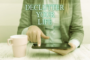 Fototapeta na wymiar Handwriting text writing De Clutter Your Life. Conceptual photo remove unnecessary items from untidy or overcrowded places Business woman sitting with mobile phone and cup of coffee on the table
