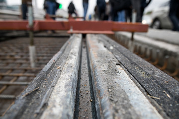 Fototapeta premium Repair of the railway tram line. Installation of new modern silent railway rails for trams. Laying of stone paving, road paving slabs on street. Repair of reconstruction of city roads with a tram line